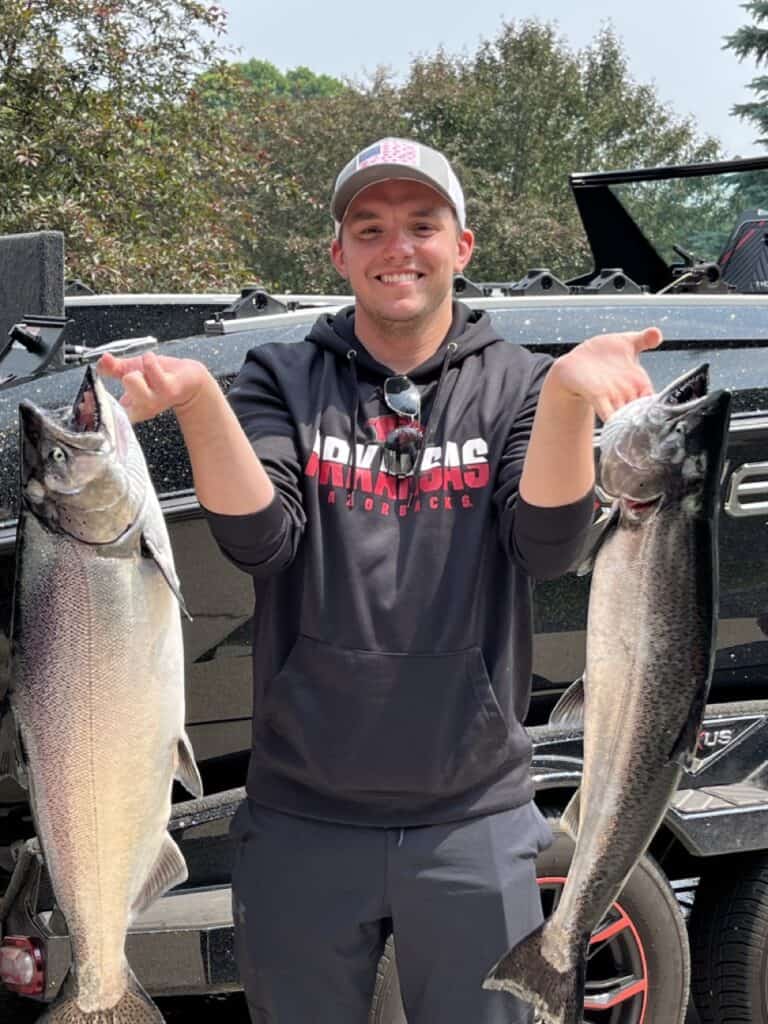 Adam holding two salmon.